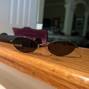 Oliver Peoples - light weight sunglasses w thin wire frame & dark green lenses.